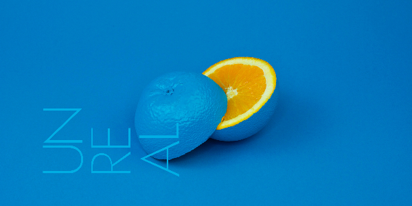 Orange painted blue and sliced in half, on blue surface